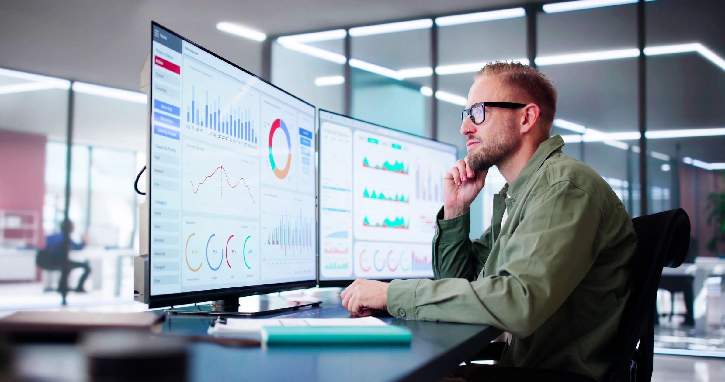Professional analyzing data dashboards on curved monitors